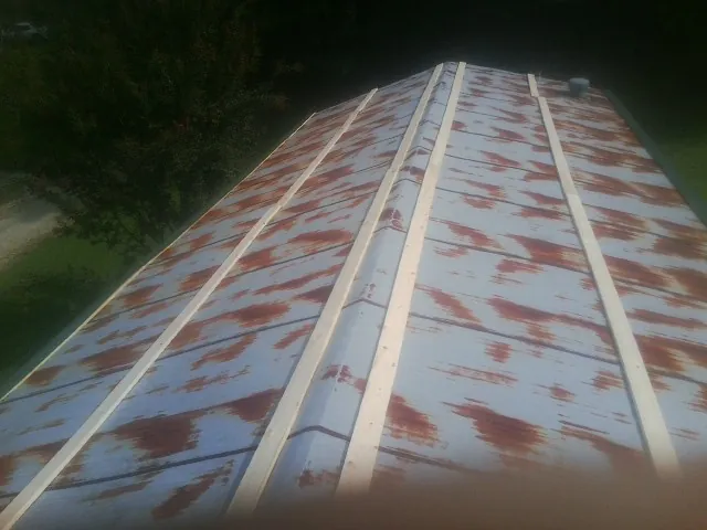 Rusted metal roof panels with new wood purlins before replacement — Storm Damage Roof Repair in Richardson by Roofing Brothers