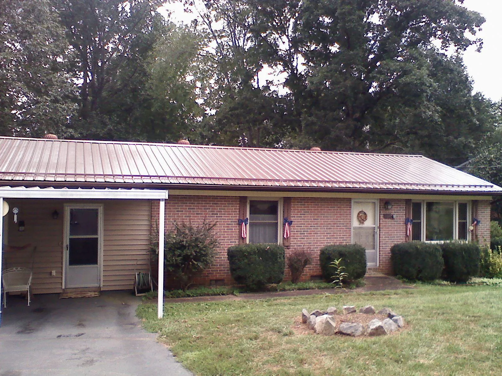 Bronze metal roof and carport on a brick ranch home — Roof Repair work by our crew in Richardson