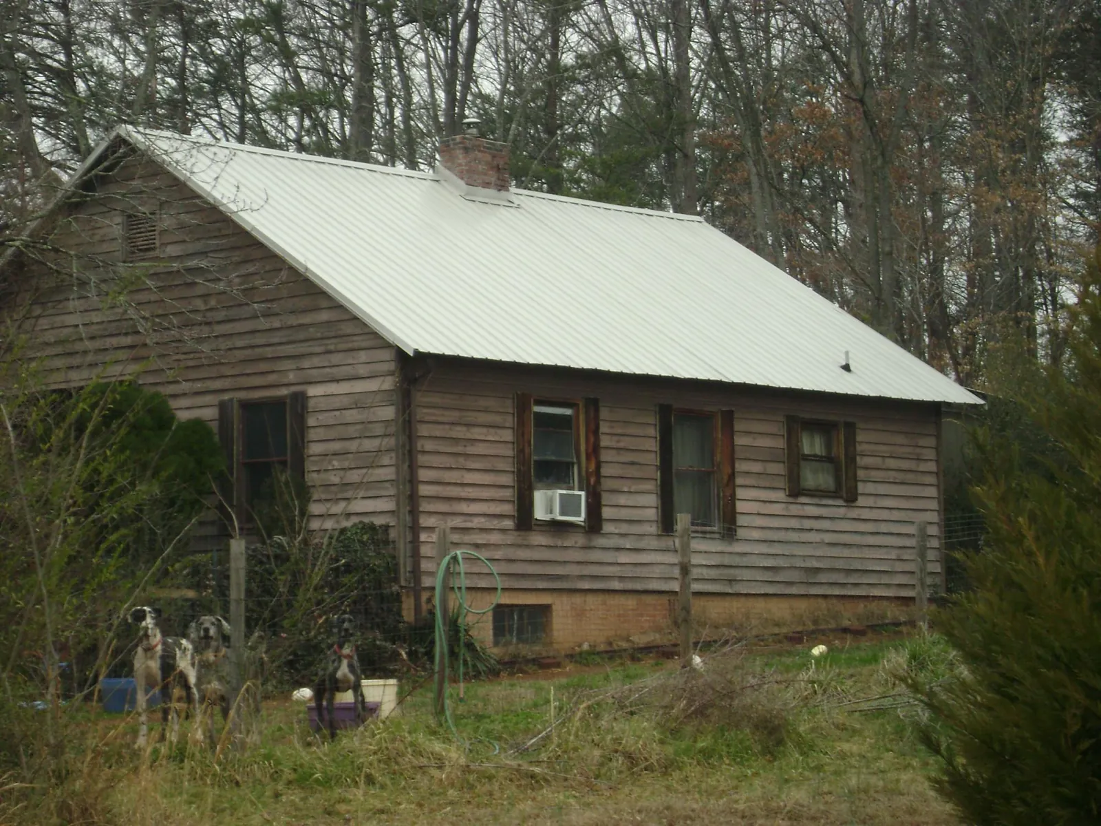 White metal roof on an old wood sided farmhouse, from a Metal Roof Installation job in Richardson